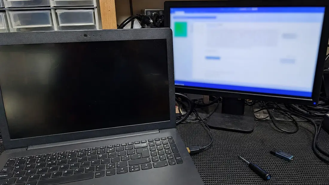 Ноутбук із чорним внутрішнім екраном, підключений через HDMI до зовнішнього монітора, на якому є зображення