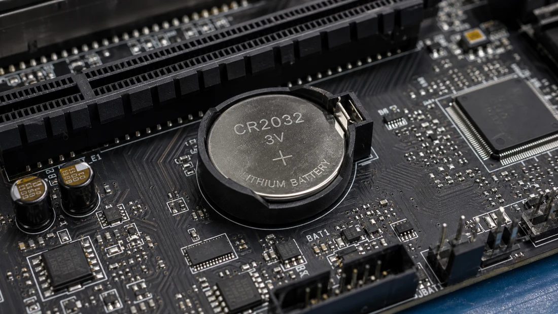 A CR2032 coin-cell battery in its socket on a motherboard